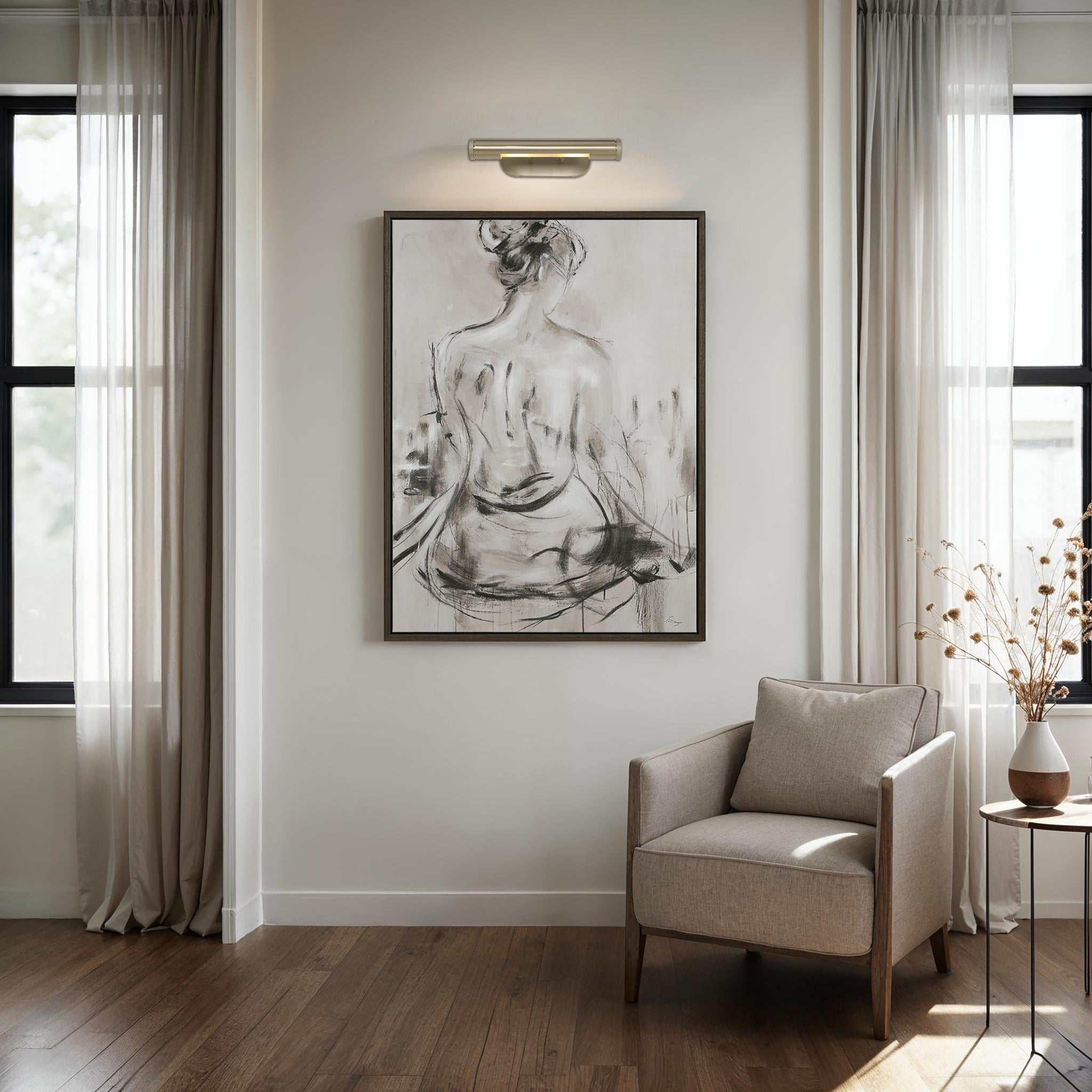 Opale wall sconce illuminating a wall art piece in a modern living room setting with natural light.