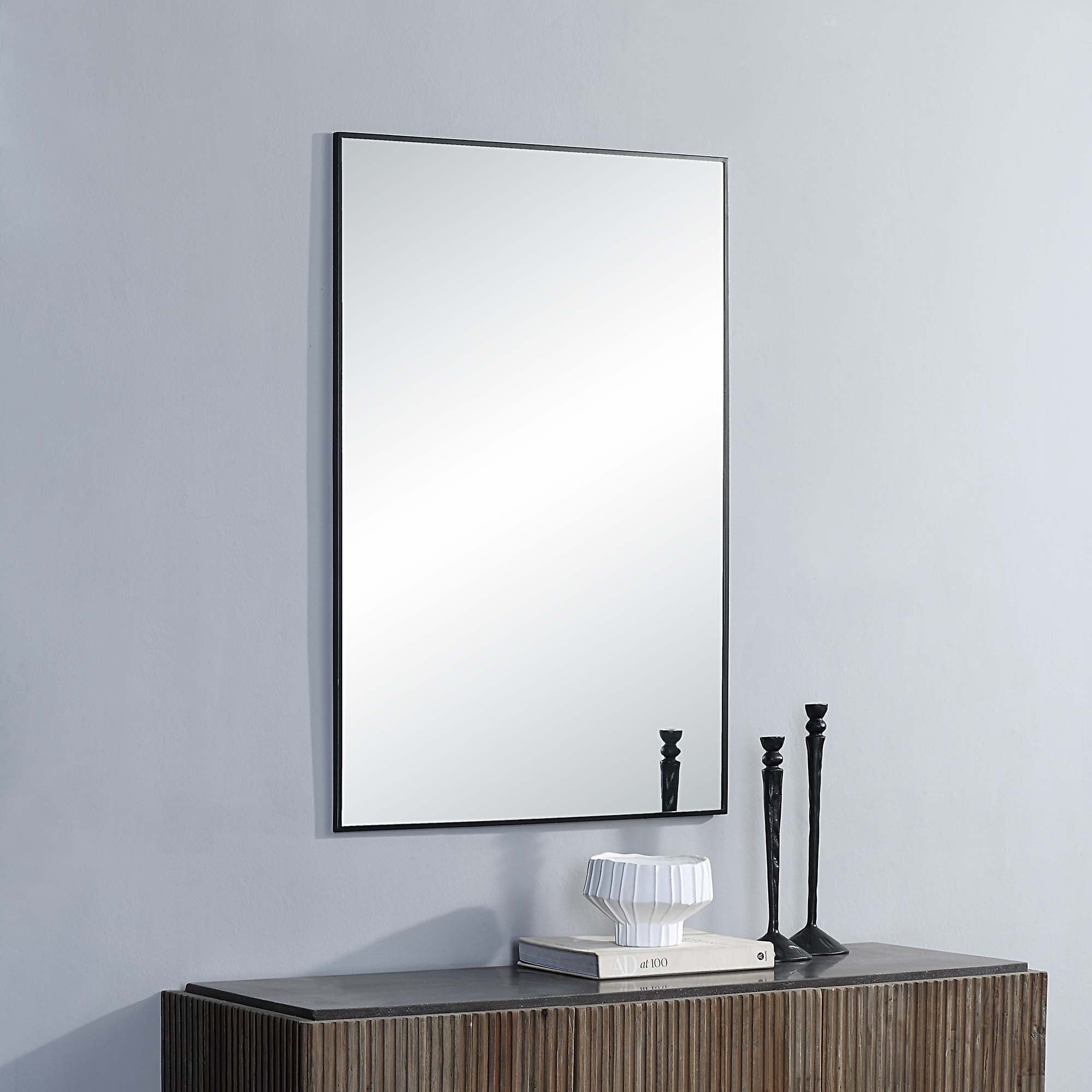Amara Wall Mirror displayed on a wall above a wooden console with decorative items.
