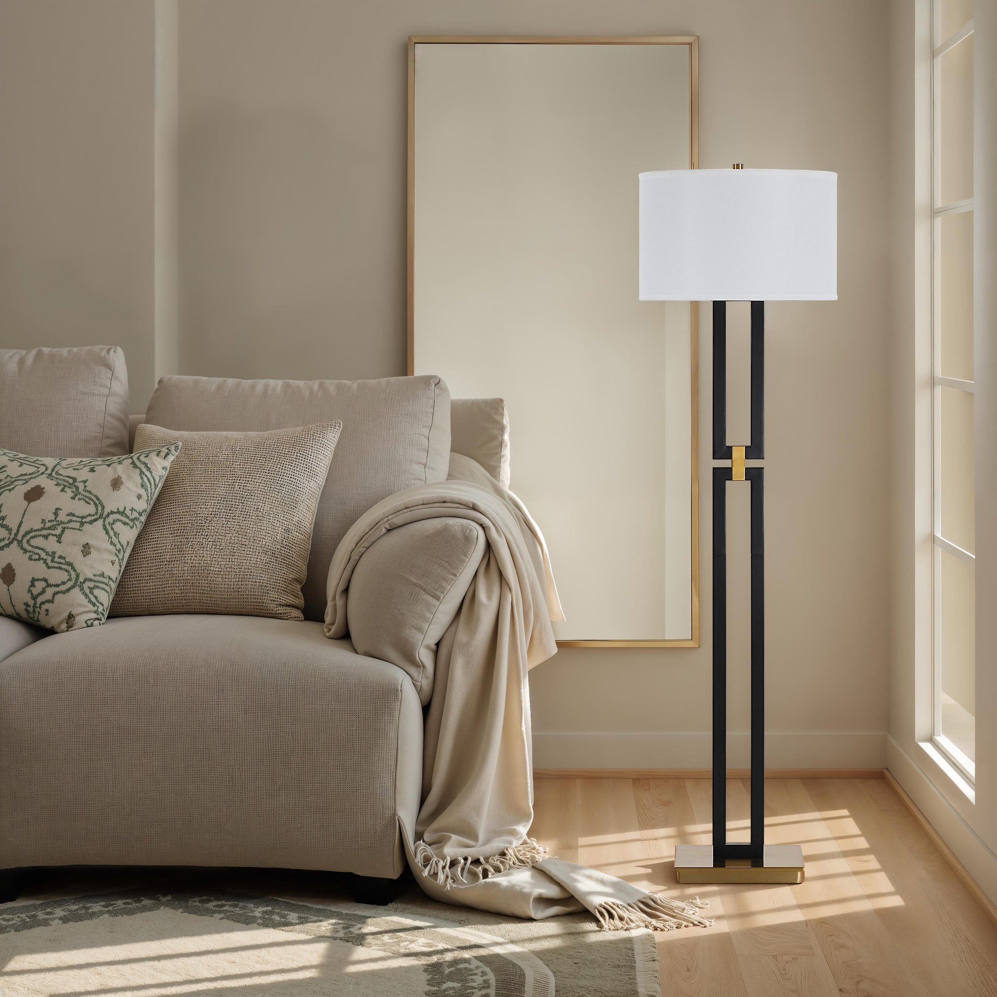 Theo Floor Lamp next to a cozy sofa with decorative pillows and a mirror.