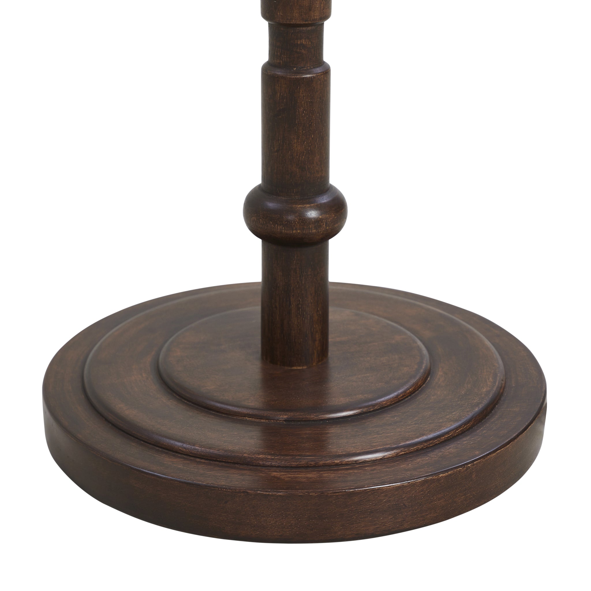 Close-up of Odlam floor lamp's dark wooden base with circular design details.