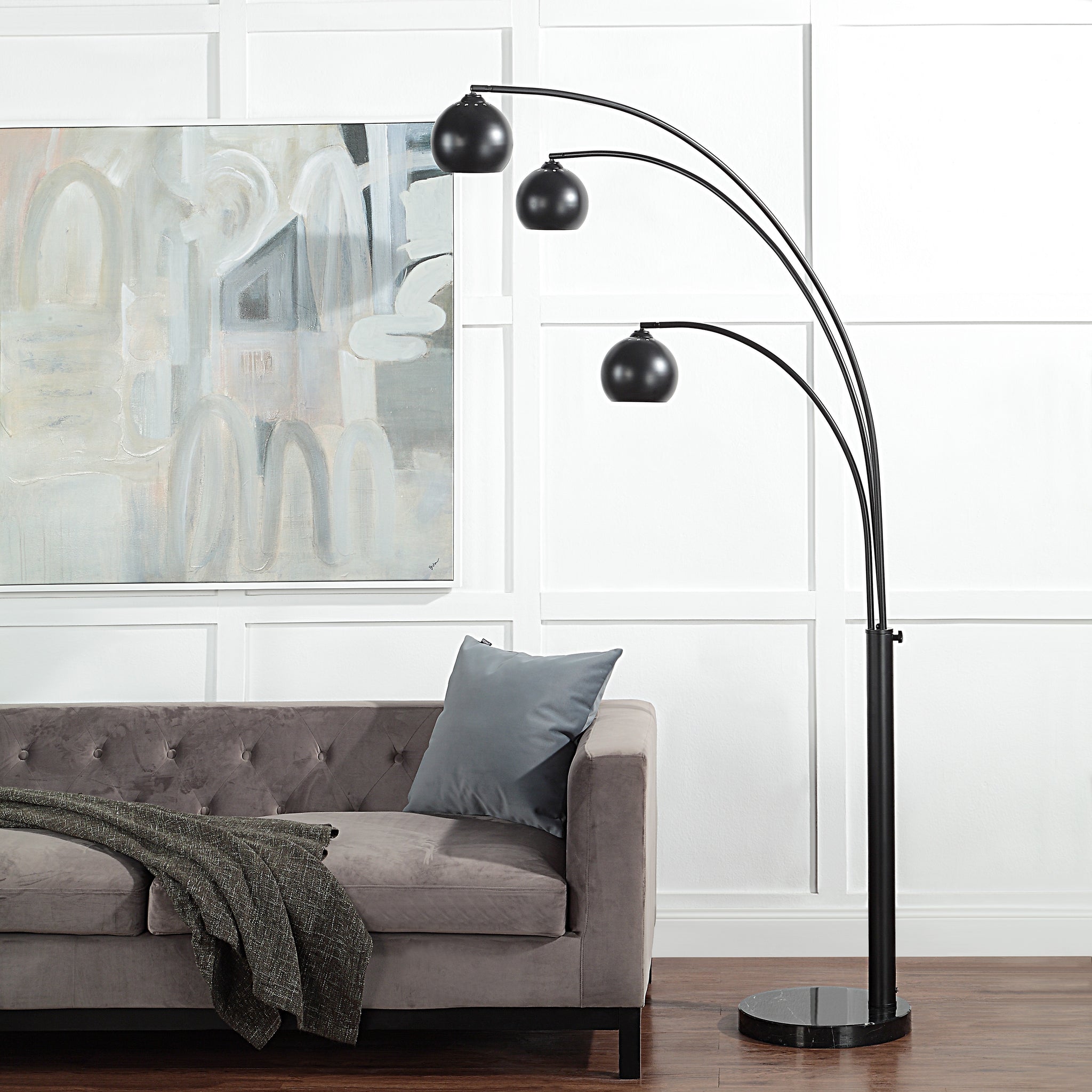 Folia Floor Lamp placed beside a gray sofa with a decorative pillow and artwork on the wall.