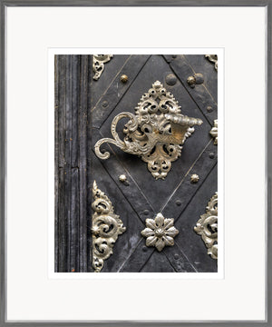 European Door Detail IV wall art featuring ornate silver hardware on a dark wooden door.