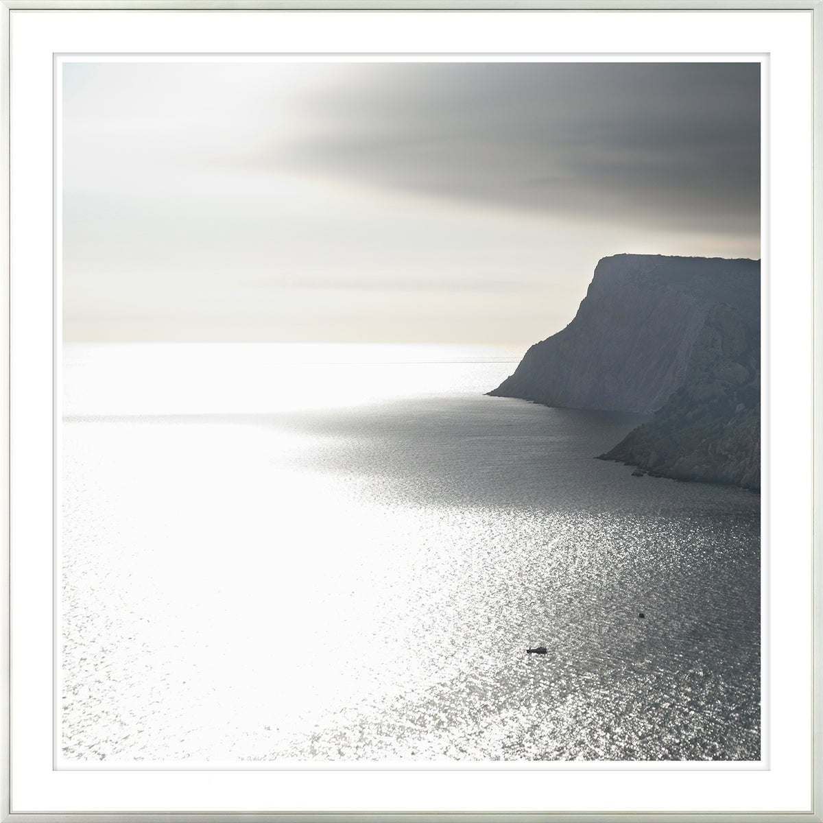 Silver Sea wall art featuring a serene coastal view with shimmering water and a distant cliff.