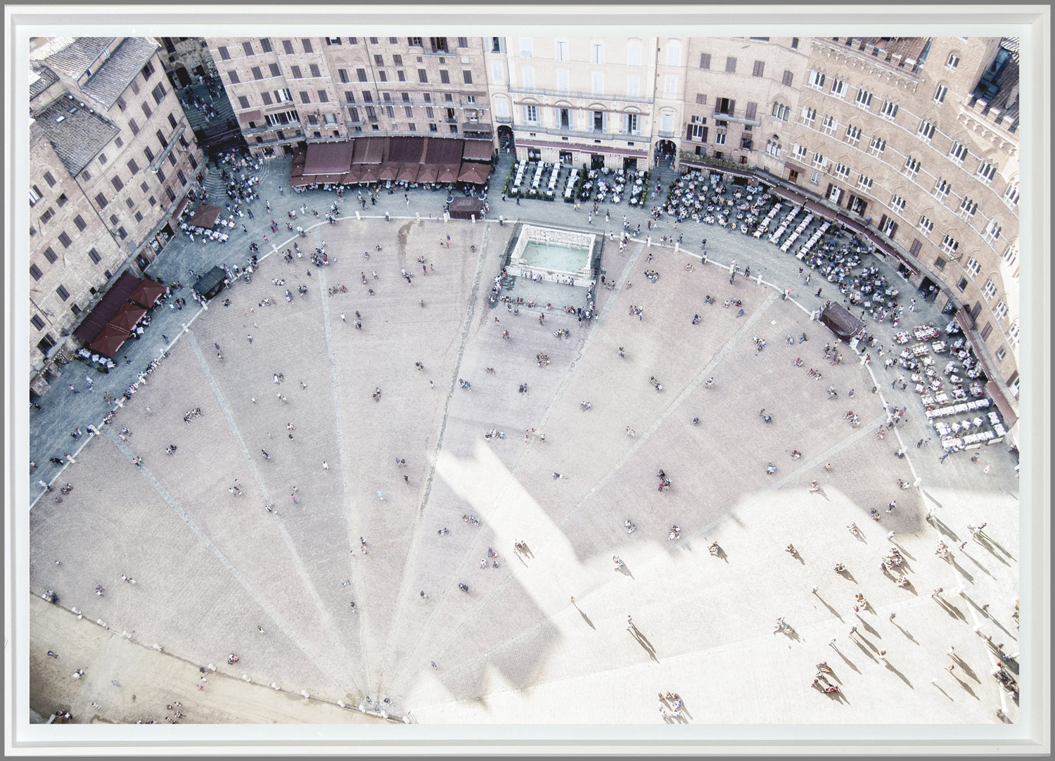 Piazza De Campo, an aerial view of a bustling square with people, cafes, and a central fountain, featuring sandy tones.