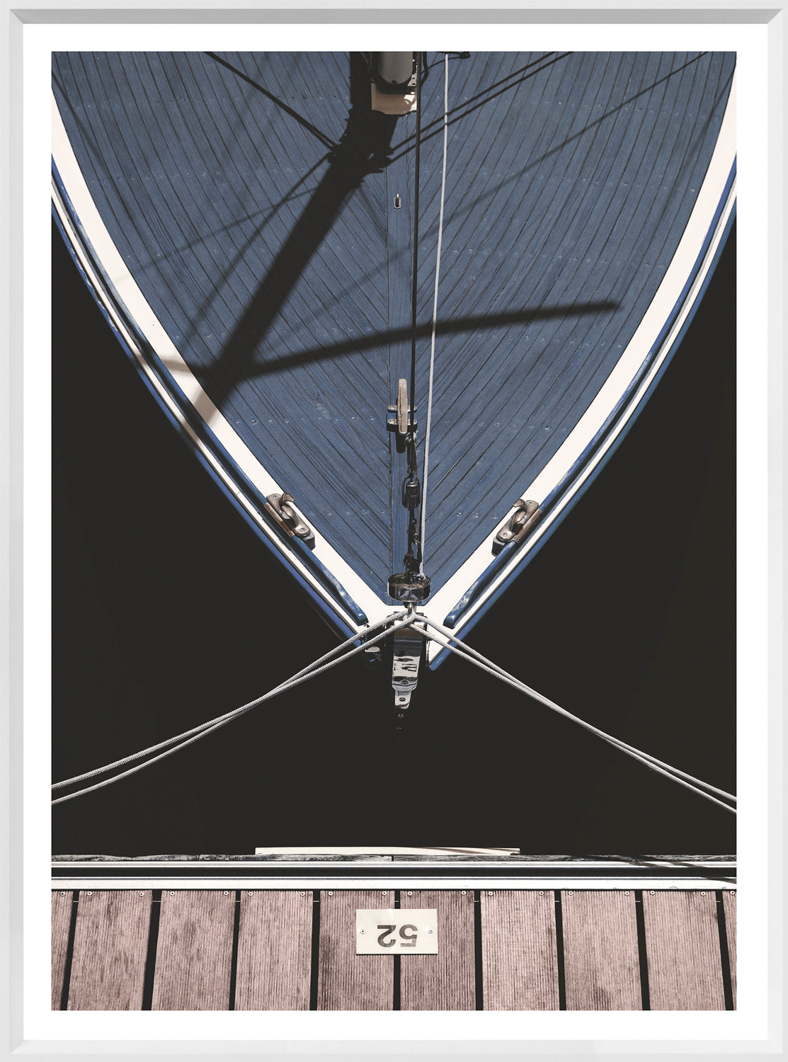 Slip '52' wall art featuring a top view of a blue boat and wooden dock.