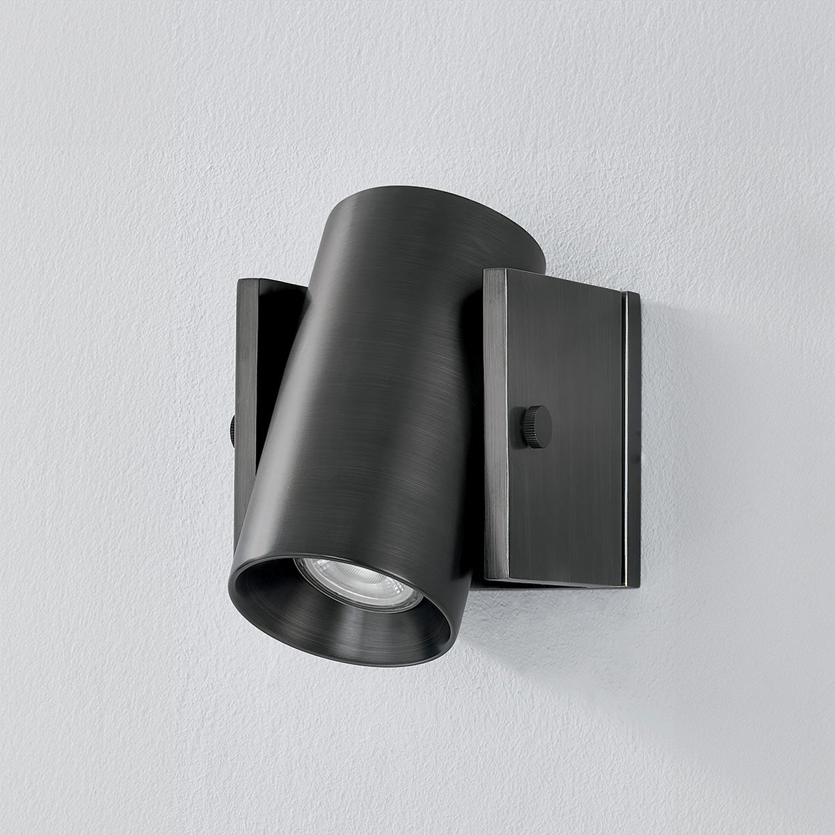 Close-up of the Nowra Wall Sconce in Aged Brass showing the arm curve and shade silhouette.