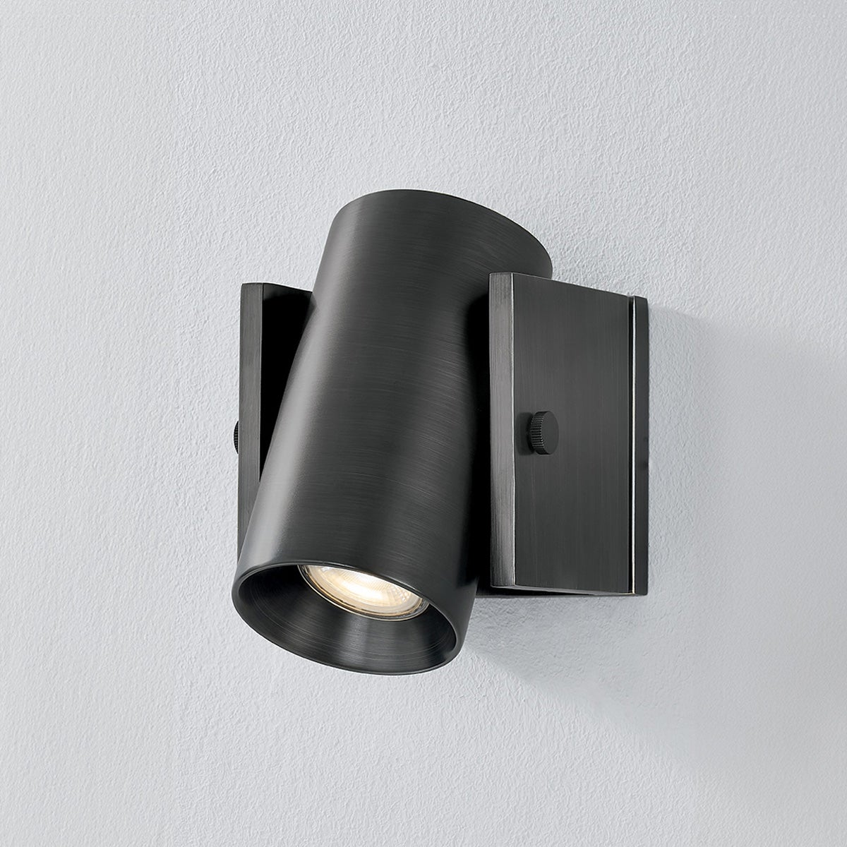 Close-up of the Nowra Wall Sconce in Aged Brass showing the arm curve and shade silhouette.