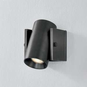 Close-up of the Nowra Wall Sconce in Aged Brass showing the arm curve and shade silhouette.