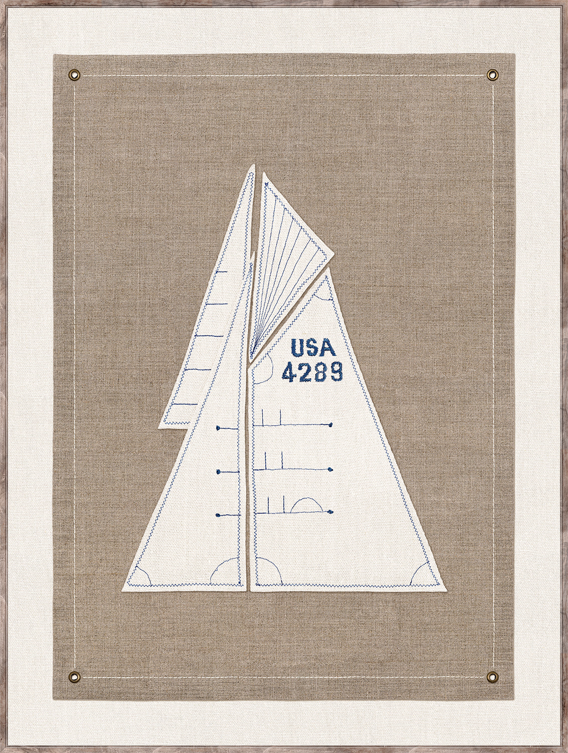 Set Sail I wall art featuring a sailboat design in blue embroidery on a beige linen background.