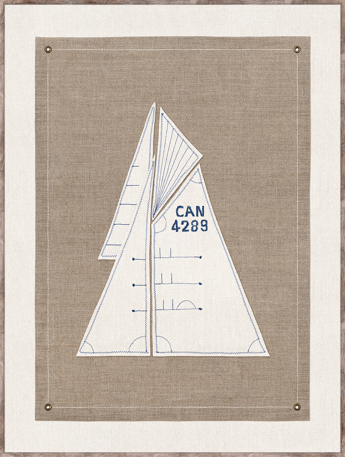 Set Sail I wall art featuring a sailboat design in blue embroidery on a beige linen background.