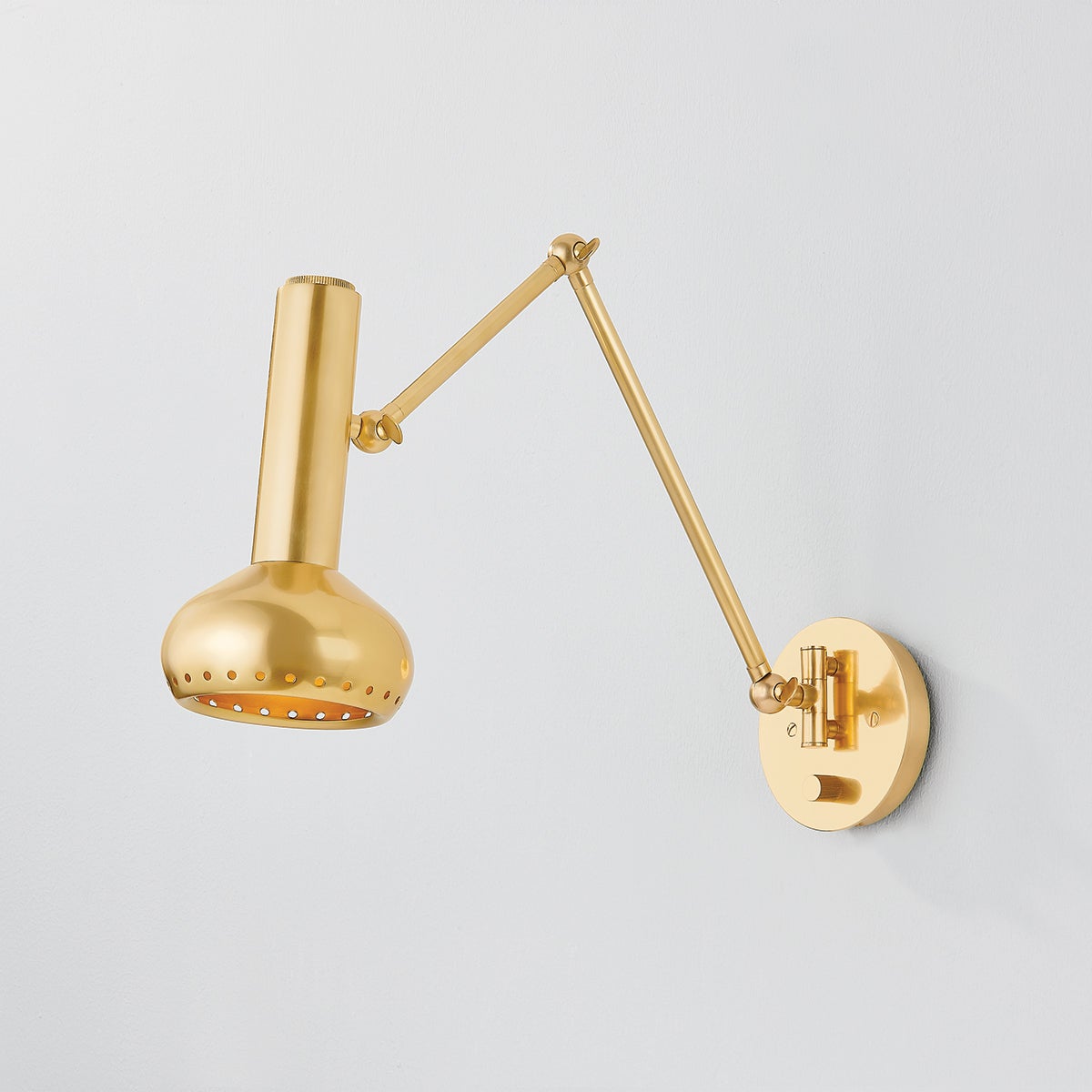 Close-up of the Roald Wall Sconce in aged brass showing the arm curve and shade silhouette.
