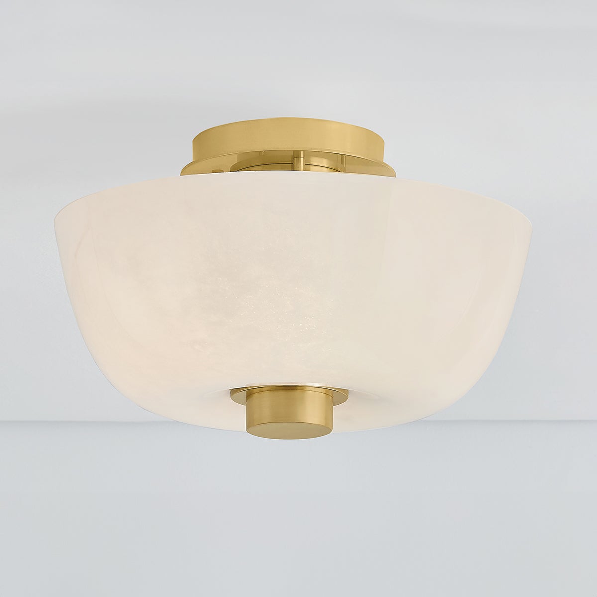 Dove Flush Mount in aged brass shown from a second angle to highlight the shade profile and mounting canopy.