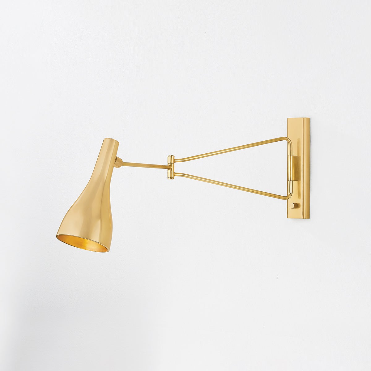 Close-up of the Northford Wall Sconce in aged brass showing the arm curve and shade silhouette.