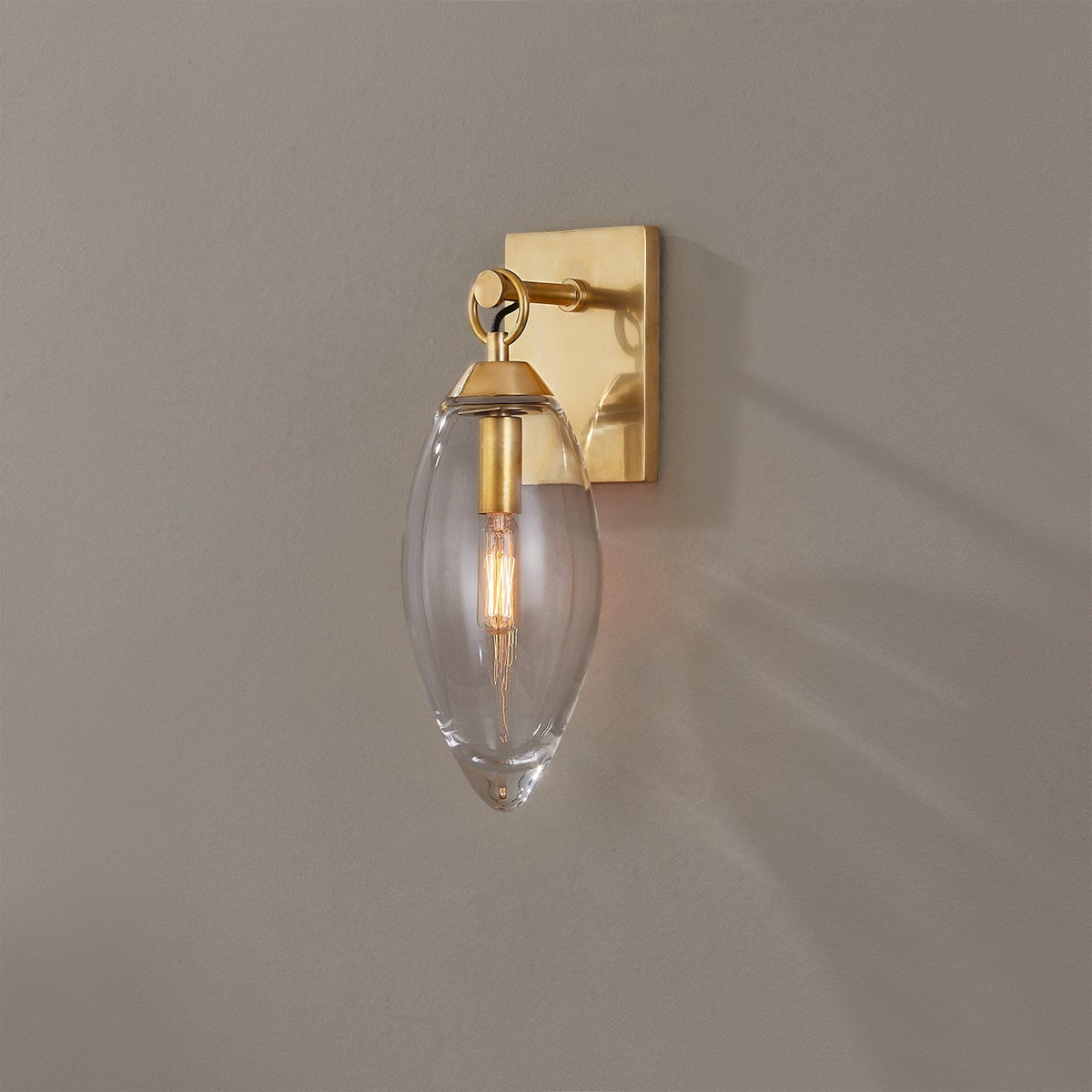 Close-up of the Nantucket Wall Sconce in aged brass showing the arm curve and shade silhouette.