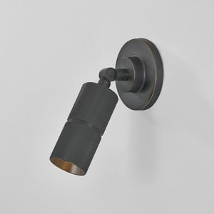 Close-up of the Truett Wall Sconce in dark bronze showing the arm curve and shade silhouette.