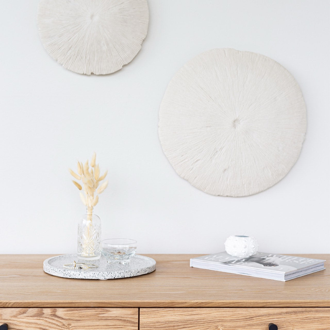 Wooden console table with decorative items against a white wall