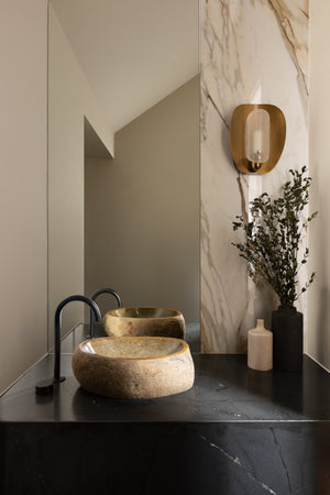 Adler Wall Sconce styled in a modern bathroom for warm, layered light at Laurie Yapp Home.