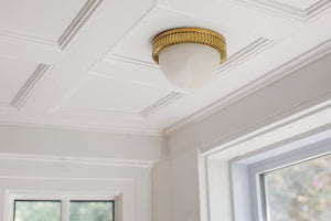 Ainsley Flush Mount in aged brass styled in a bedroom for warm, layered light at Laurie Yapp Home.