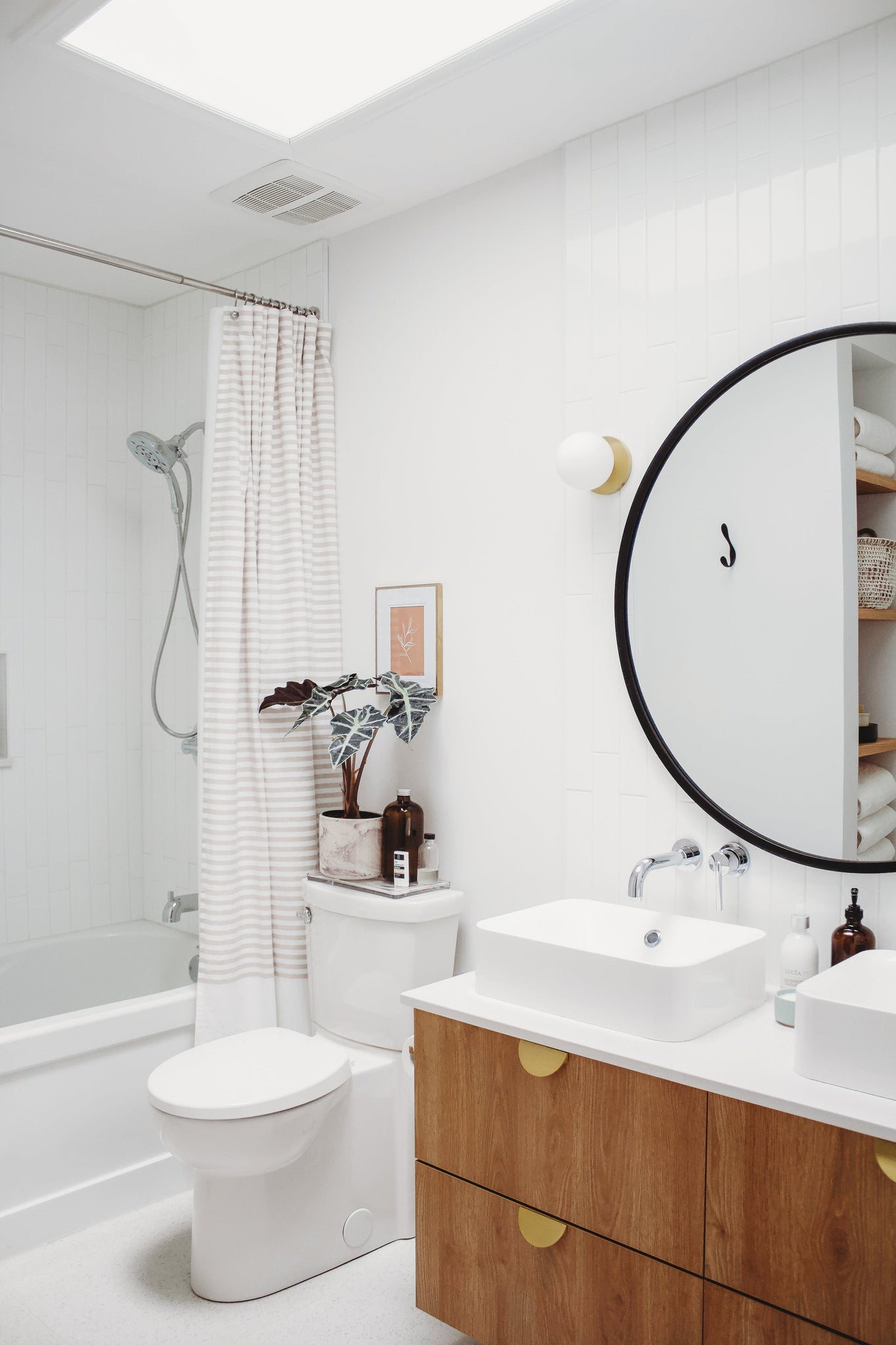 Close-up of the Baird Bath And Vanity 4.75" in aged brass showing the arm spread and shade silhouette.
