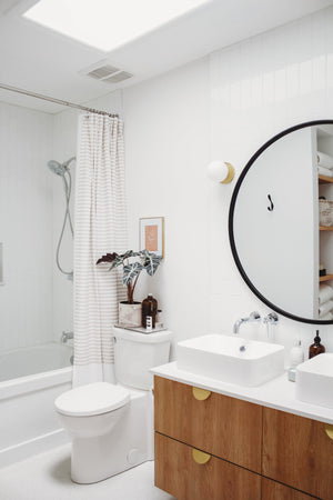 Close-up of the Baird Bath And Vanity 4.75" in aged brass showing the arm spread and shade silhouette.
