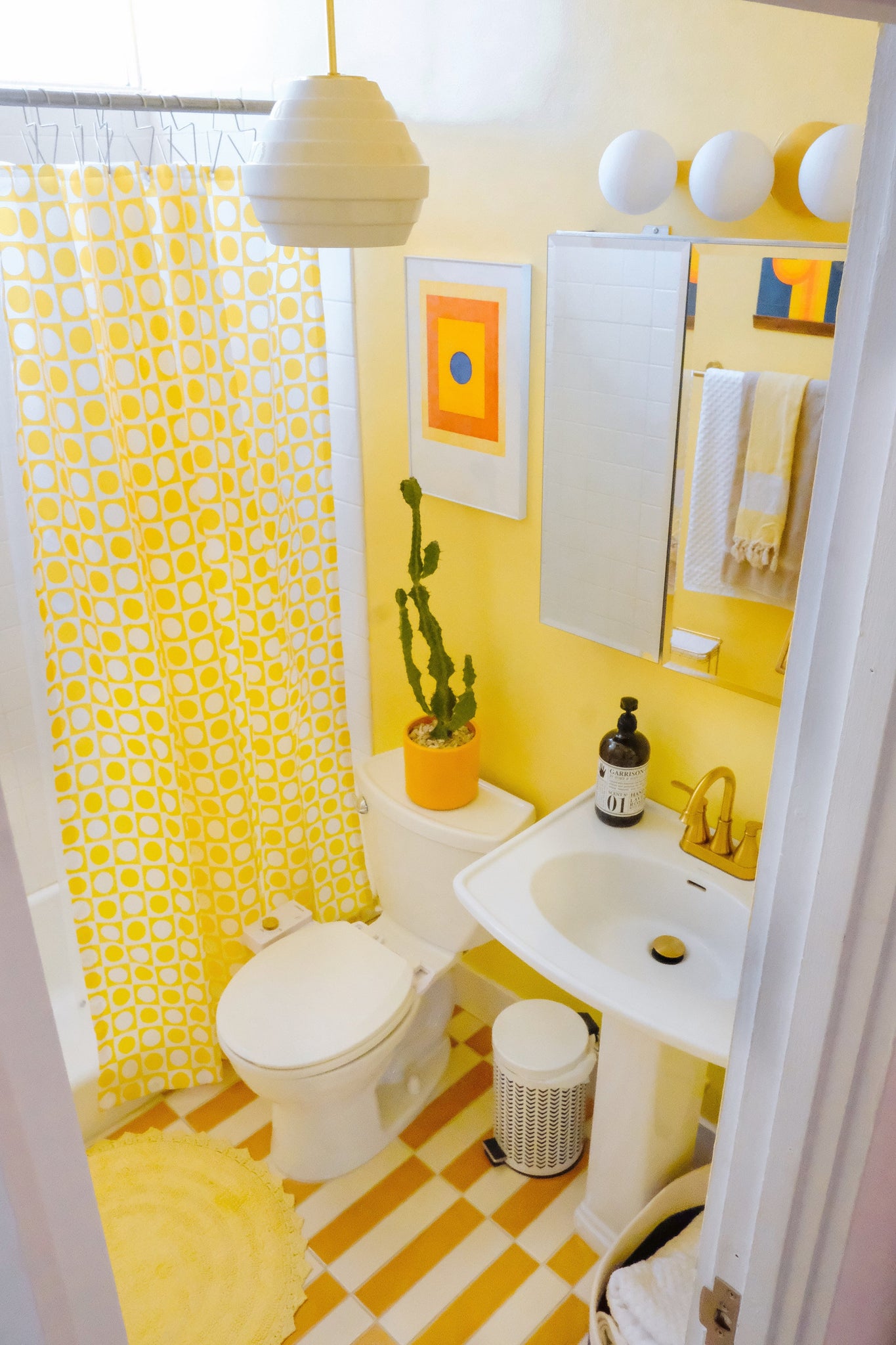 Baird Bath And Vanity 23.5" in aged brass shown from the front to reveal the arm spread and shade silhouette.
