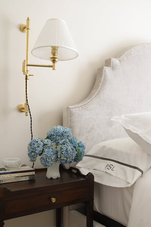 Classic No.1 Plug-In Sconce in aged brass styled in a reading nook for warm, layered light at Laurie Yapp Home.