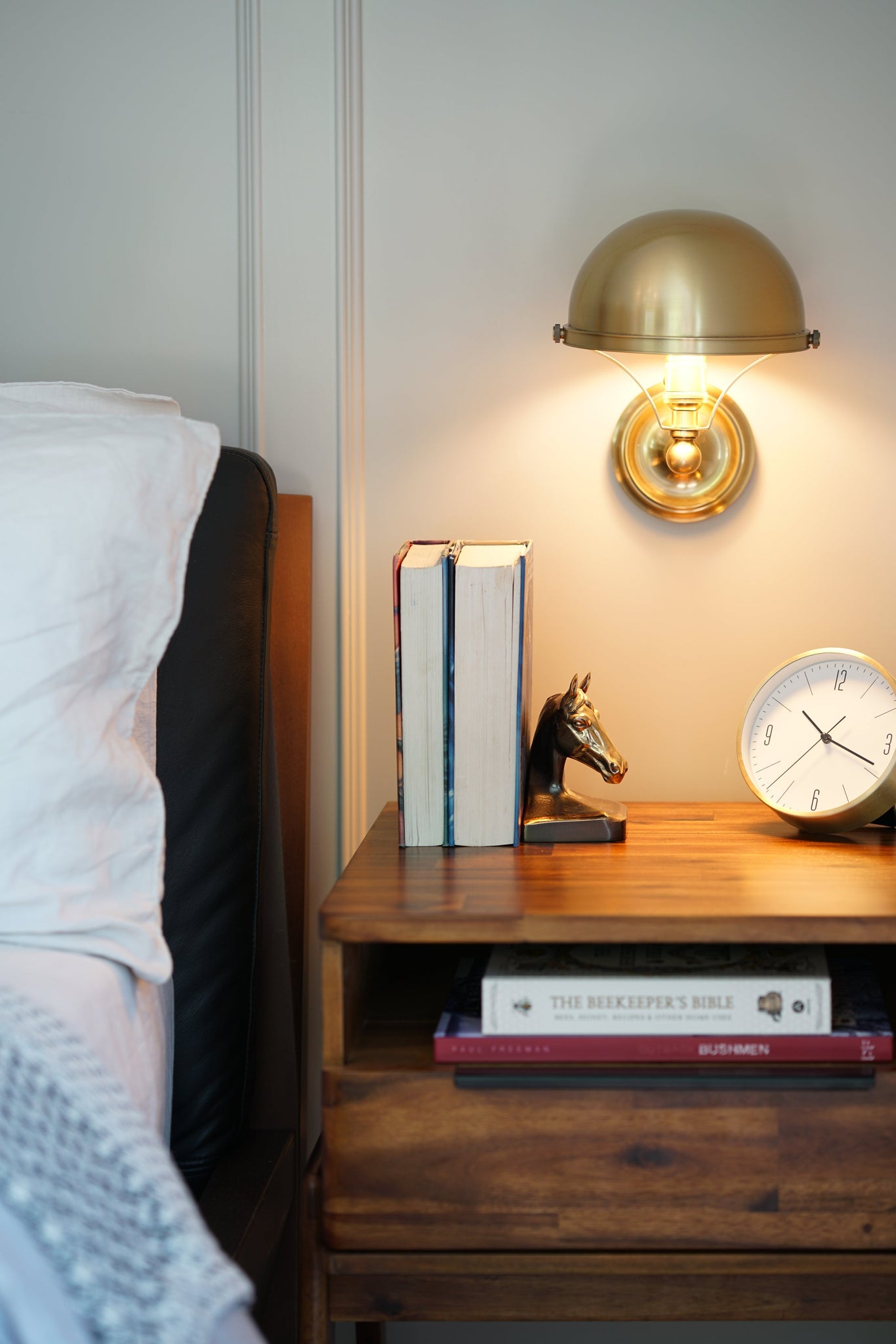 Covington Wall Sconce in aged brass shown from the front to reveal the arm curve and shade silhouette.
