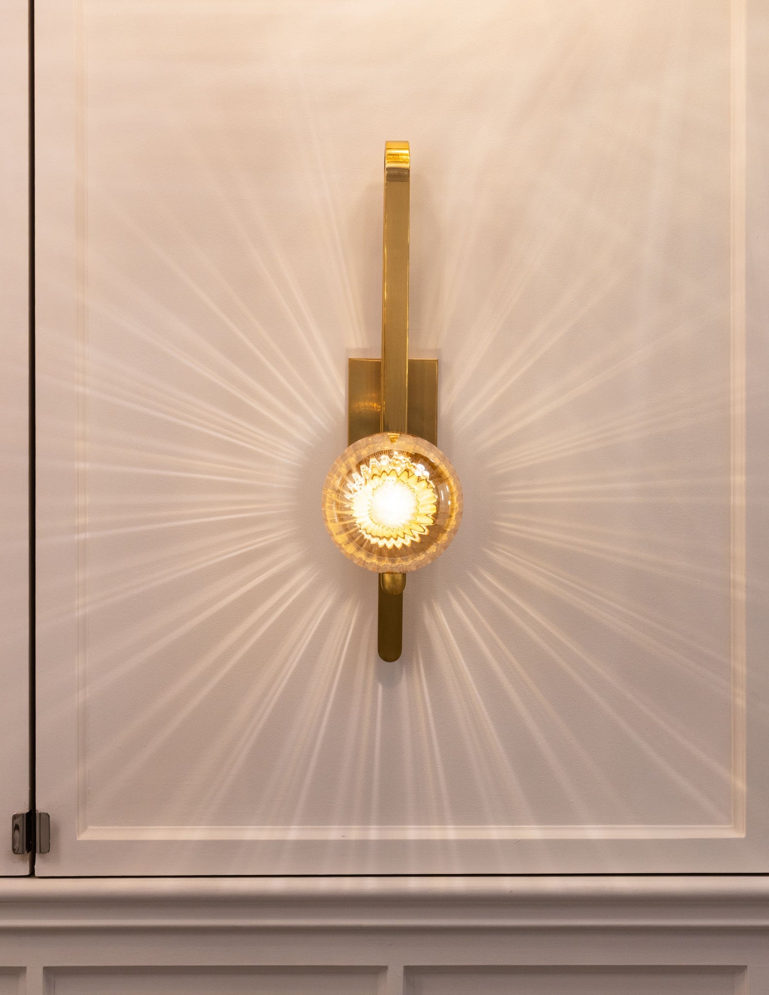 Cronus Wall Sconce styled in a warmly lit hallway for warm, layered light at Laurie Yapp Home.