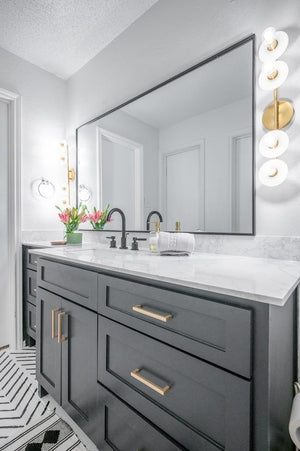 Close-up of the Elmont Bath And Vanity 4.75" x 24.75" in aged brass showing the arm spread and shade silhouette.