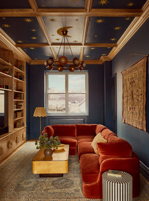 Glimmer Chandelier in aged brass styled in an elegant dining room for warm, layered light at Laurie Yapp Home.