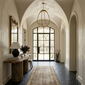 Lloyd Pendant 18.5" in aged brass styled in a welcoming entryway for warm, layered light at Laurie Yapp Home.