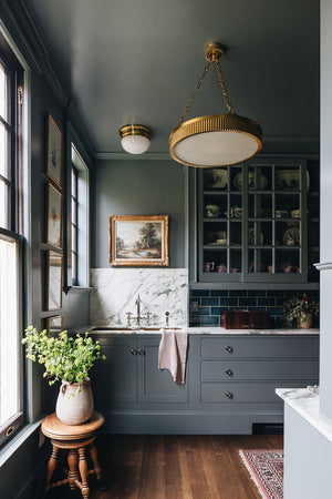 Lynden Chandelier 22" in aged brass styled in an elegant dining room for warm, layered light at Laurie Yapp Home.