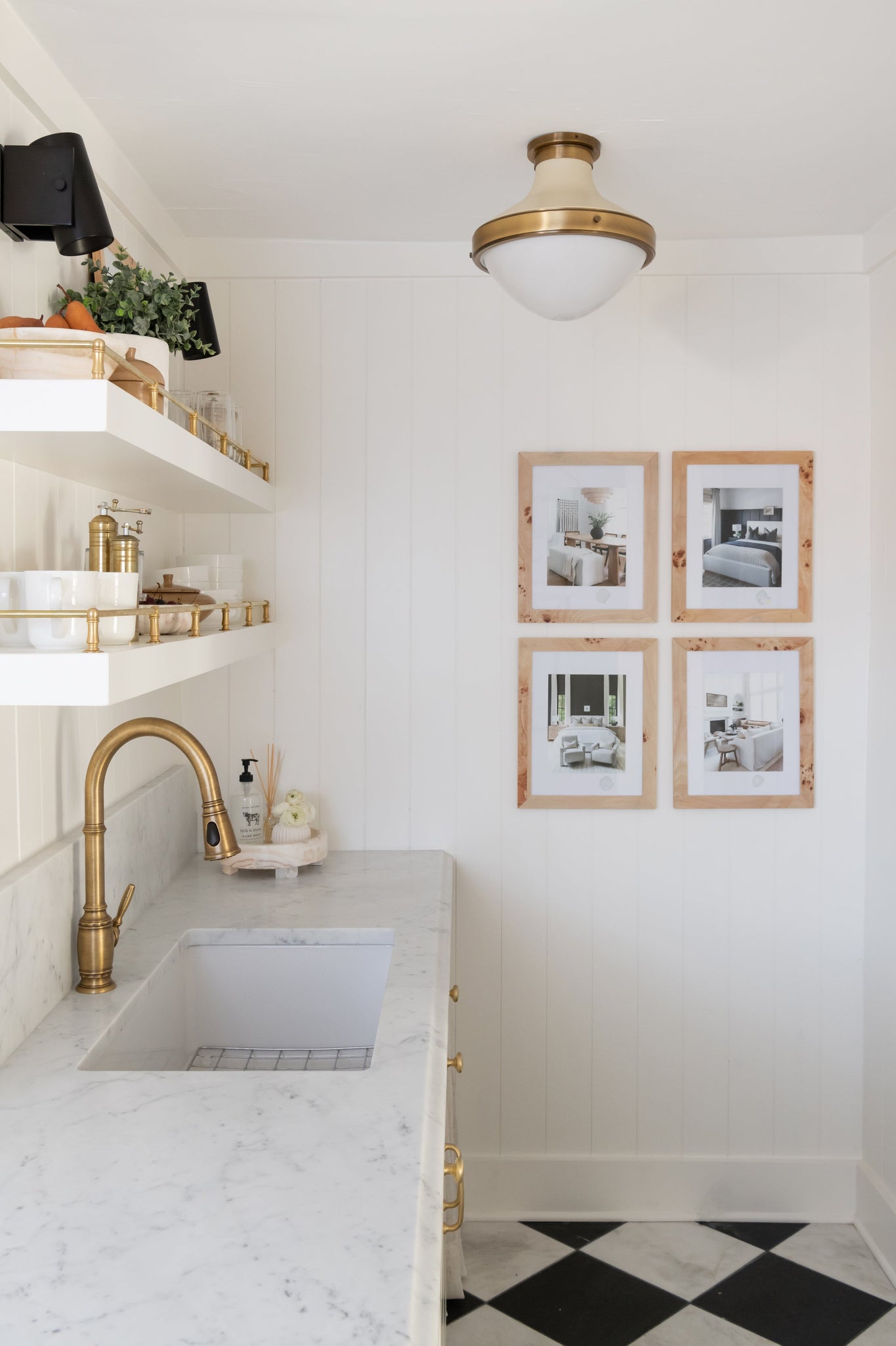Nowra Wall Sconce in Aged Brass styled in a warmly lit hallway for warm, layered light at Laurie Yapp Home.
