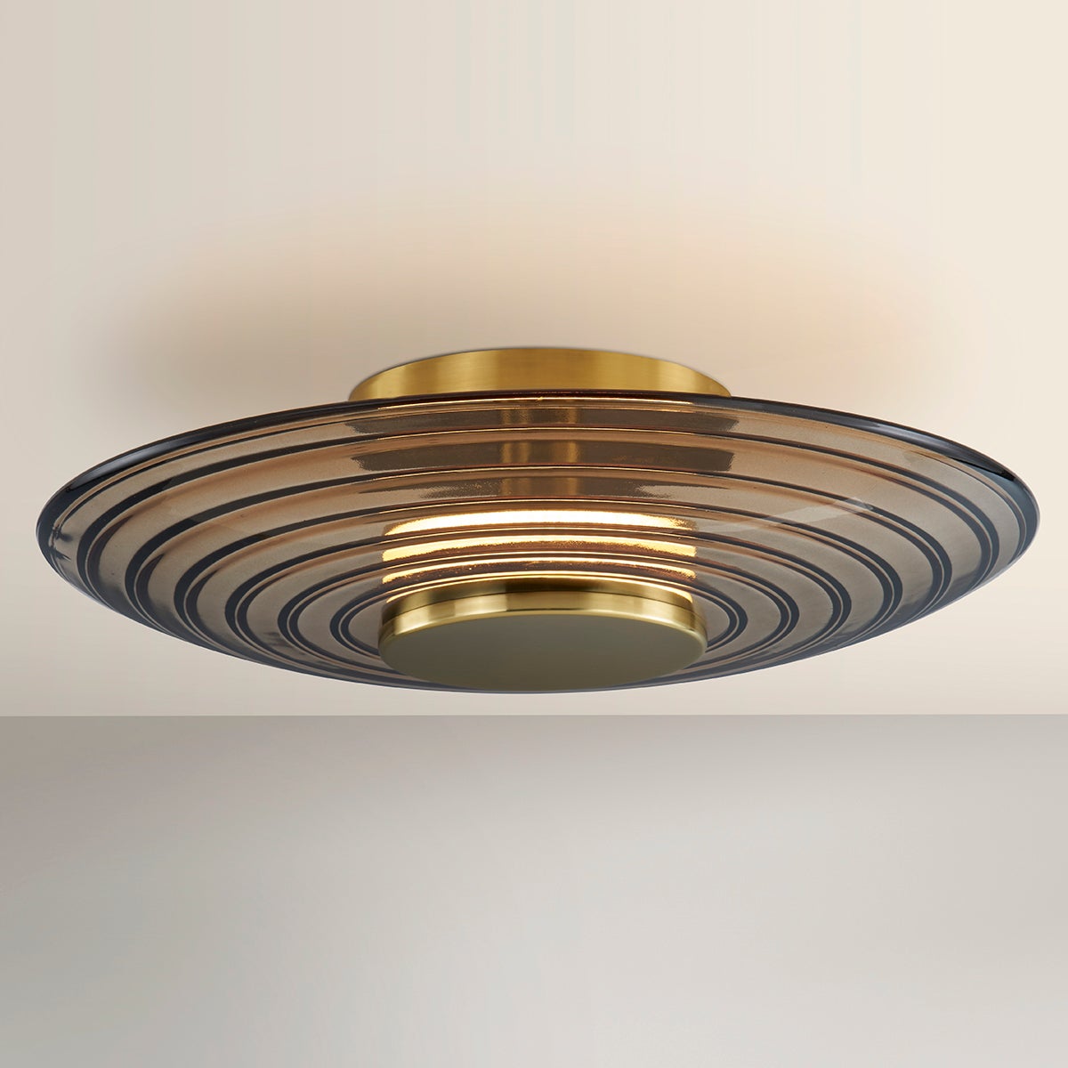 Close-up of the Griston Wall Sconce 12" x 12" in aged brass showing the arm curve and shade silhouette.