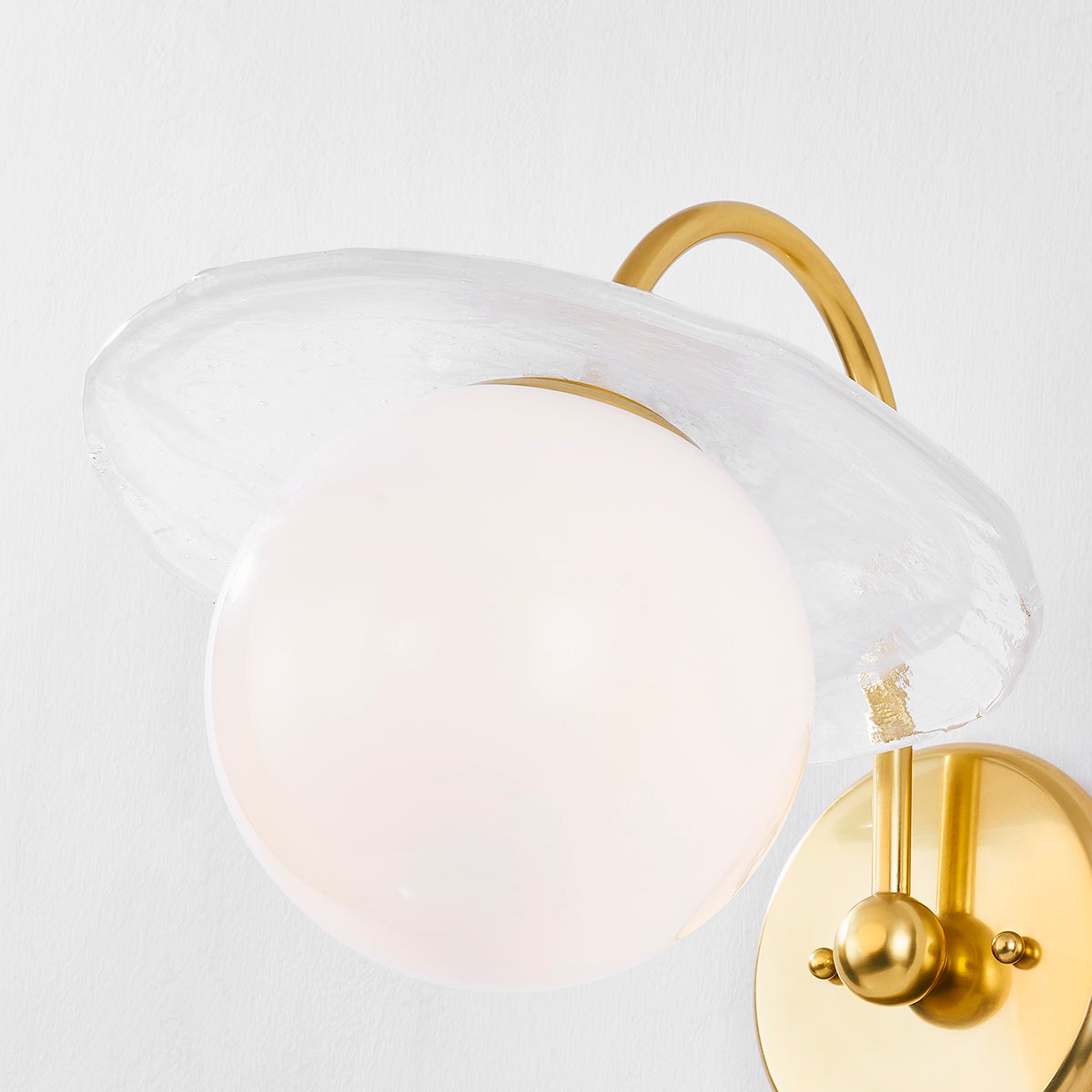 Stampford Wall Sconce in aged brass shown from the front to reveal the arm curve and shade silhouette.