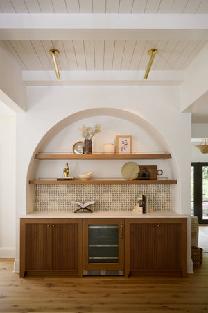Simeon Wall Sconce in aged brass styled in a modern bathroom for warm, layered light at Laurie Yapp Home.