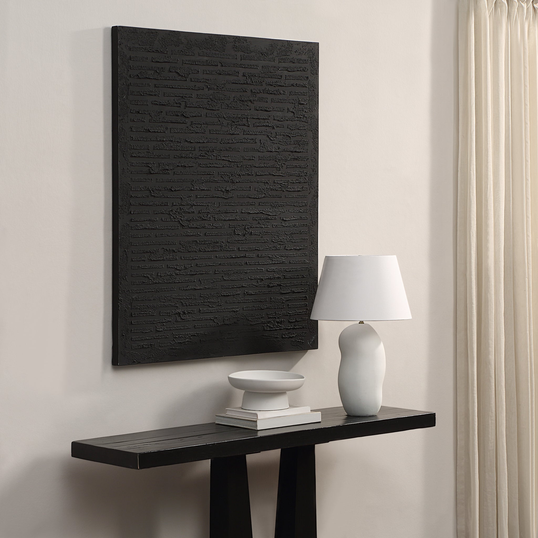 Kinetic canvas art by Renwil mounted on a wall above a console table with decor items.