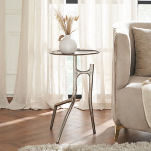 Tosco table styled with a vase and dried flowers, placed beside a sofa.