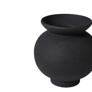 Cadiz vase by Renwil, black ceramic vase with a rounded shape, placed on a marble table with flowers.