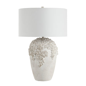 Wavy table lamp with a textured white base and a white fabric shade