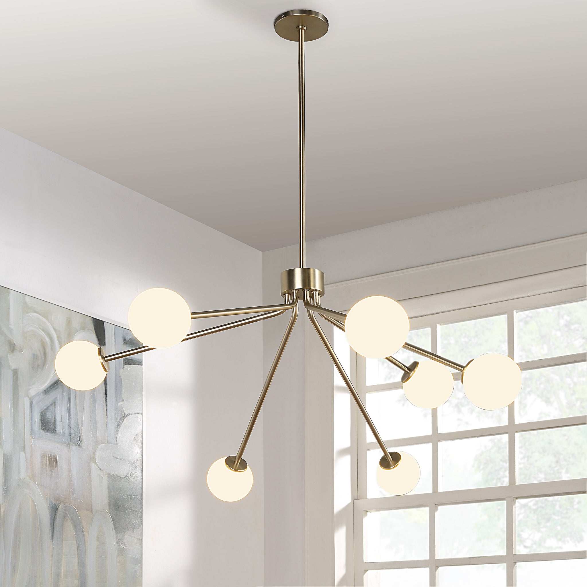 Mundo Ceiling Fixture with illuminated white globes, gold finish, modern design in a bright room.