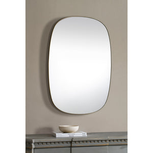 Gallegos Wall Mirror displayed on a wall above a table with decorative items.