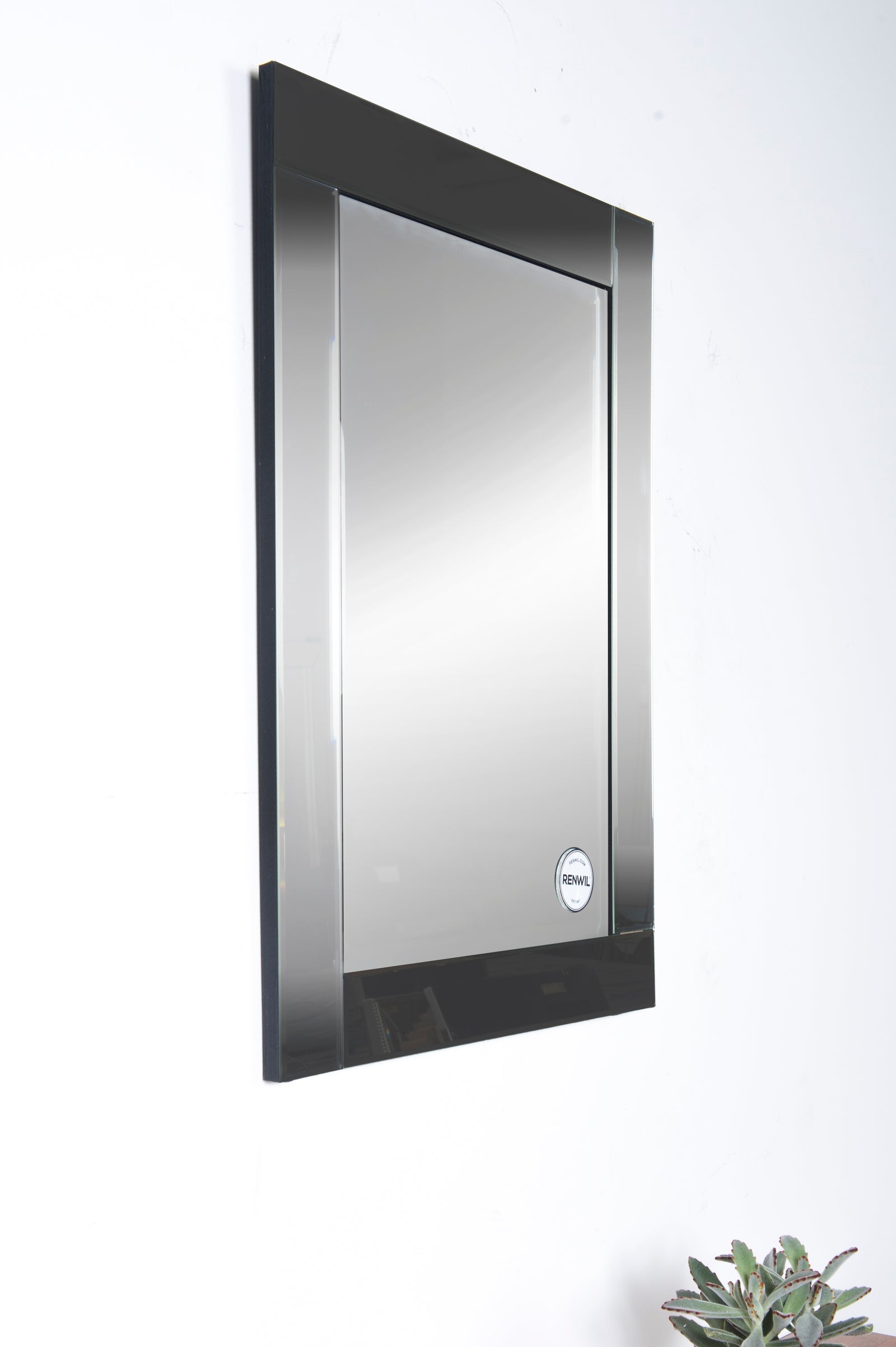 Adan Wall Mirror with a sleek rectangular design and polished edges, reflecting light.