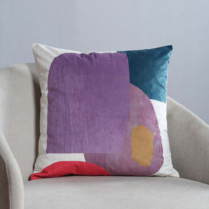 Layla Indoor Pillow displayed on a light gray chair, showcasing abstract design in purple and teal.