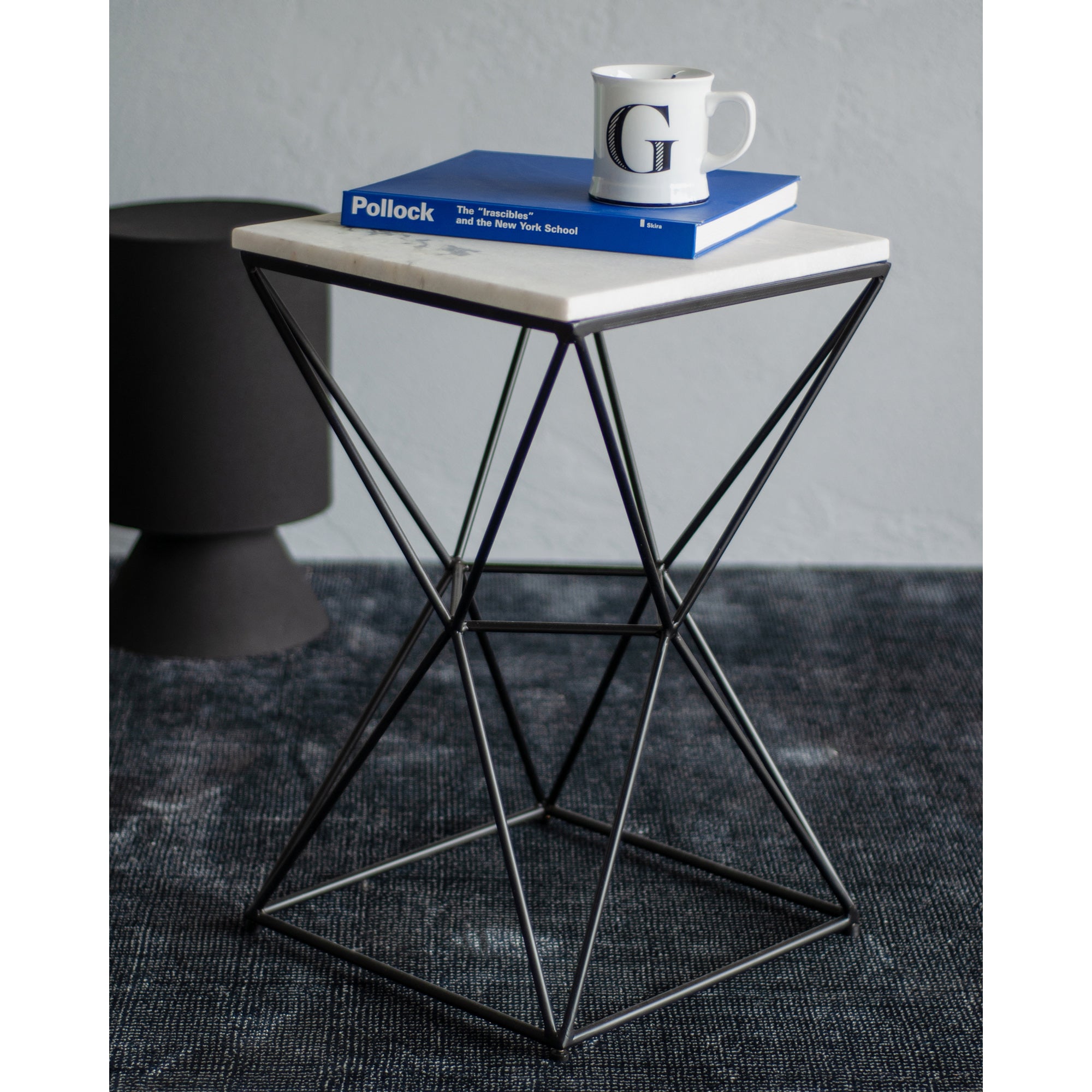 SYMMETRY table styled with a book and mug on a white marble top