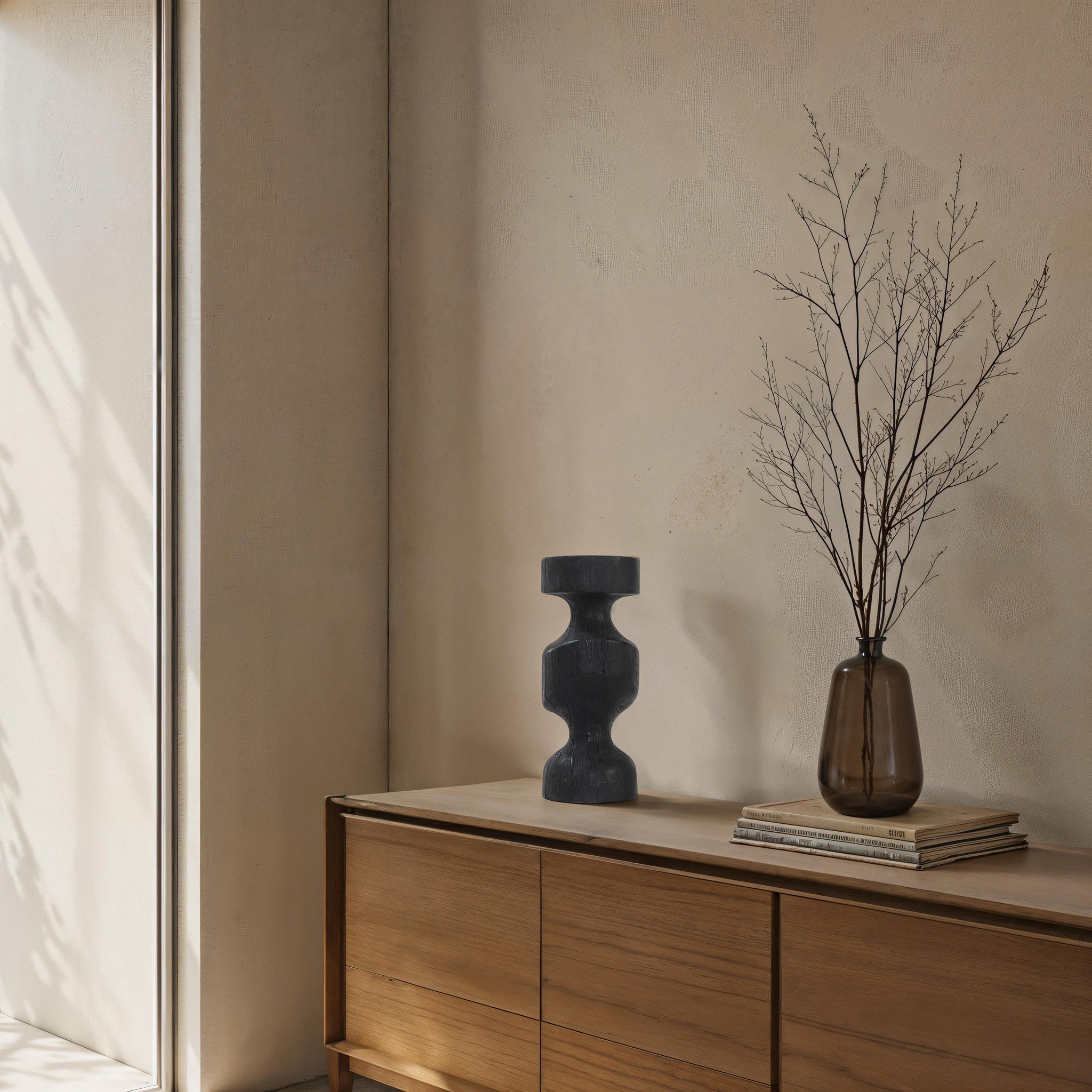 Severn by Renwil black wooden candle holder on a wooden dresser with a vase and dried branches.