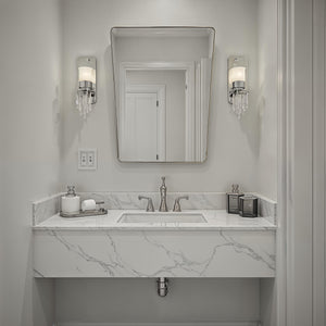 Mily mirror above a modern bathroom sink with marble countertop and stylish fixtures.