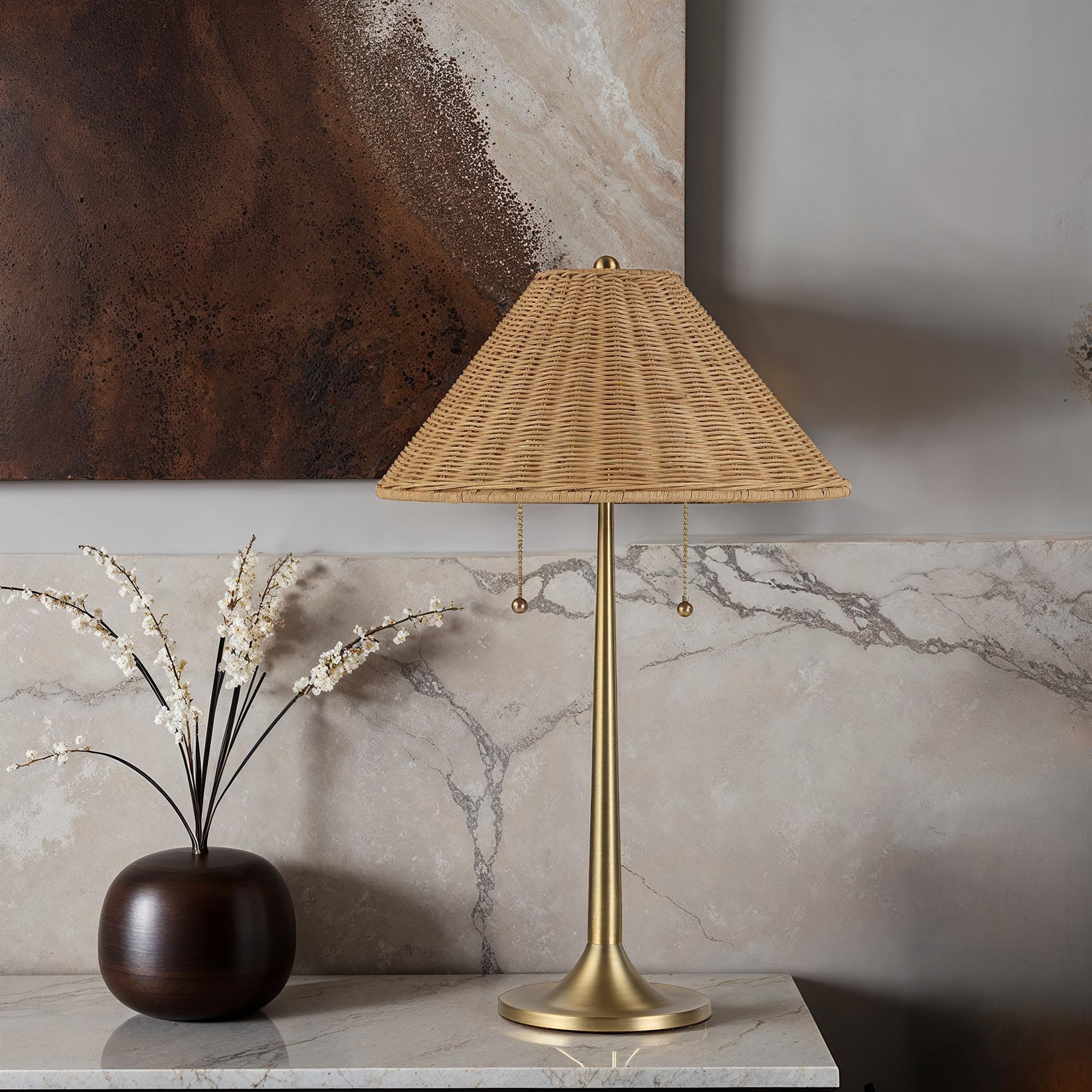 Viana Table Lamp on a marble surface beside a dark vase and decorative branches, with a textured shade.