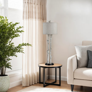 Leandro Table Lamp placed beside a beige sofa on a wooden side table.