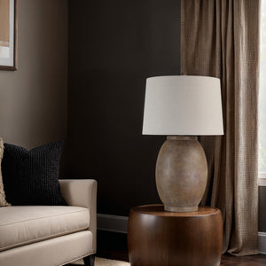 Naima Table Lamp placed beside a beige sofa in a cozy living room setting